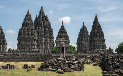Ornate volcanic stone temple with multiple pointed spires at Amanjiwo resort, Indonesia.