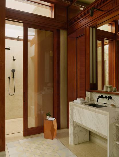 Salle de bains de la Hill Casita à Amanera, avec boiseries en teck et lavabo en pierre.