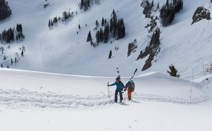 Ski concierge team with guests on snowy mountain slope at Amangani.