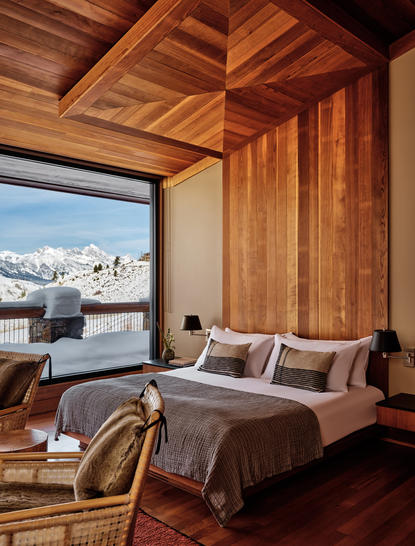 Principal bedroom at Amangani with wooden ceiling, mountain views, and contemporary furnishings.