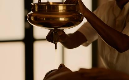 Wellness ritual with warm oil being poured at Amanbagh, India.