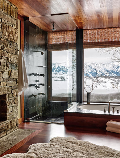 Wapiti home at Amangani with wood-lined interior, fireplace, and panoramic mountain views through floor-to-ceiling windows.