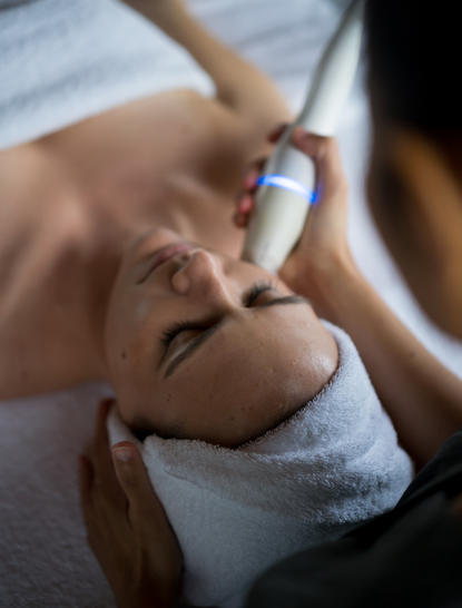 Therapeutische Behandlung an der Amanpuri: Person erhält Gesichtsmassage mit konzentriertem Ausdruck.