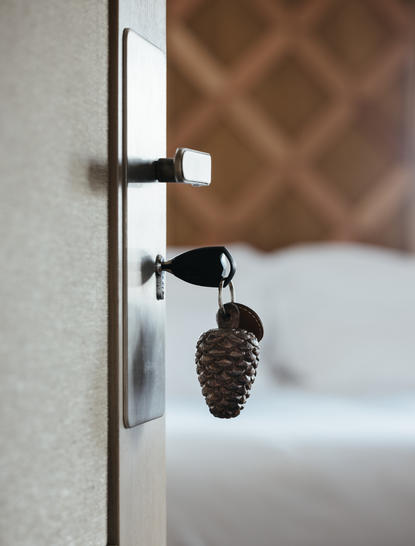 Minimalist door handle detail with geometric patterned wall at Aman Le Mélézin.