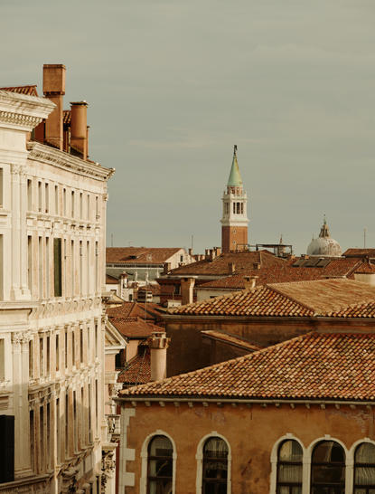 安缦威尼斯酒店Palazzo Chamber Luminoso房间，可眺望威尼斯红瓦屋顶和圣马可钟楼。