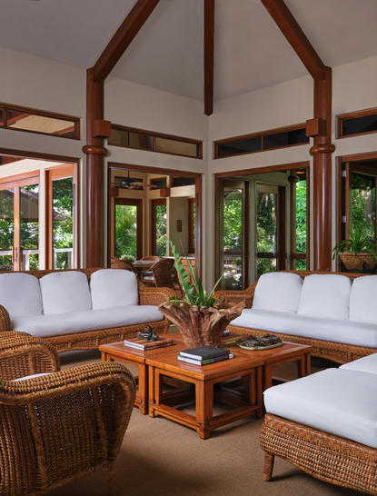 安缦璞乐度假村内饰休闲区，配有白色沙发、木制家具和落地窗。