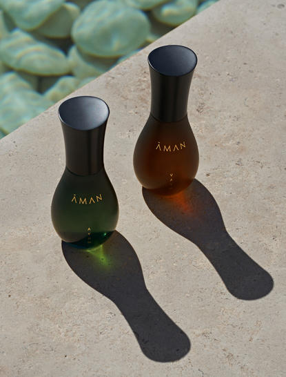 Dua flaconi di profumo per il giorno Aman Essentials su una superficie in pietra presso il resort Amanzoe.
