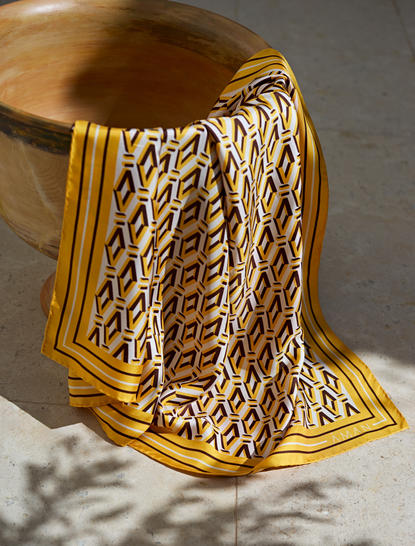 アマンゾイ リゾートの黄色いスカーフ、織りのテクスチャーが光に映える。