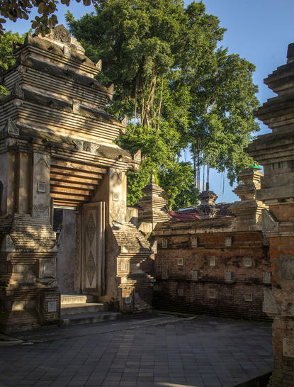Courtyard at Amanjiwo resort with stone architecture and mature trees, Yogyakarta.