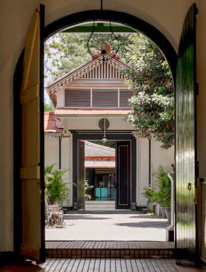 Vue à travers une arche vers un pavillon traditionnel du village à Amanjiwo.