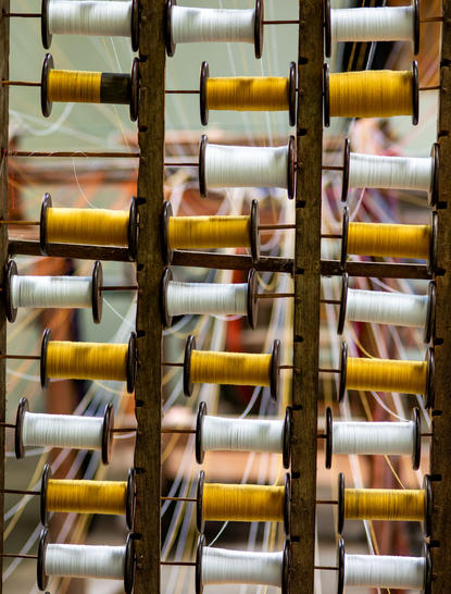 Amanjiwo resort in Yogyakarta: shelving displaying folded yellow and white linens behind dark wooden lattice screens.