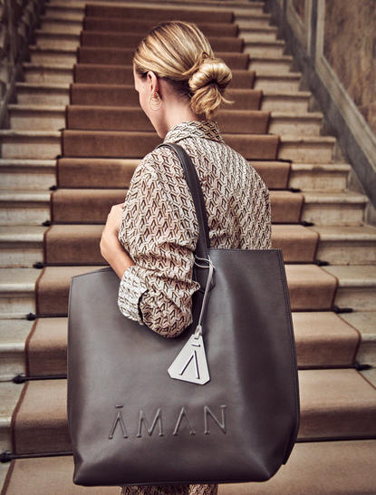 アマン ヴェニスのホテルの階段に座る、手荷物を持つ来客。