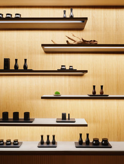 Dettagli della spa e benessere presso Aman New York, con scaffali in legno che espongono prodotti per la cura del corpo.