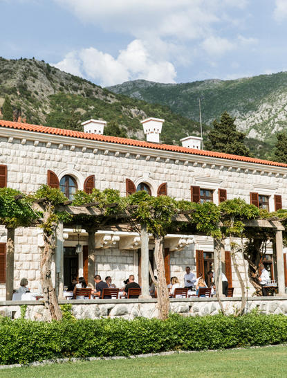 Villa Milocer restaurant with terracotta roof and manicured gardens at Aman Sveti Stefan, Montenegro.