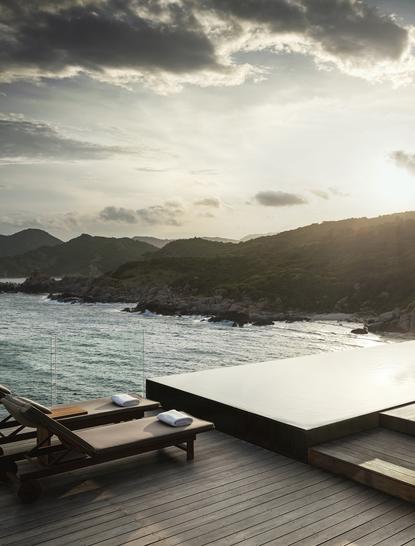 アマノイ リゾートの一ベッドルーム オーシャンプール レジデンスからの海と山々の眺め。