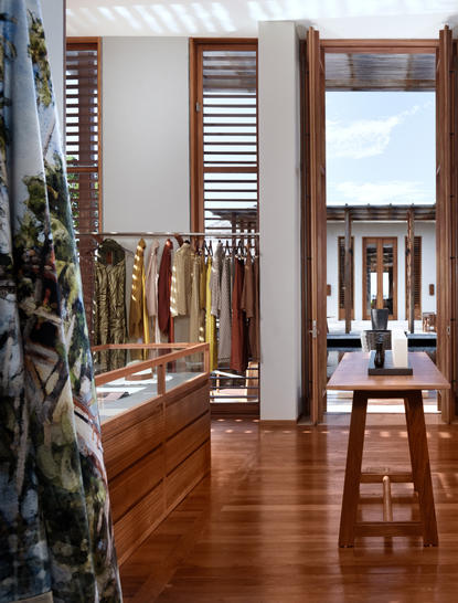 Wooden shutters frame the entrance to a boutique resort suite at Amanyara, with views through to a terrace beyond.