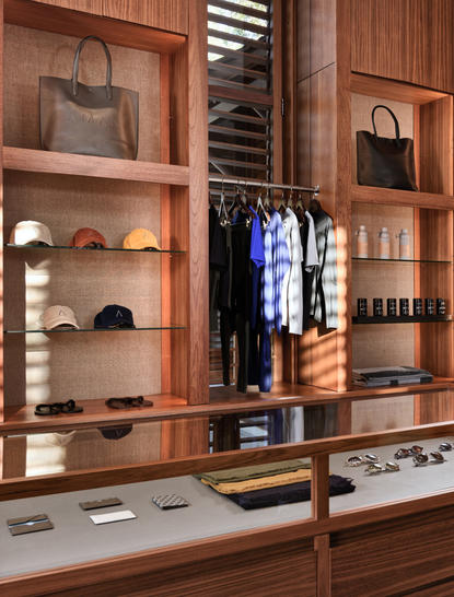 Tienda minorista de Amanyara con vitrinas de madera que exponen ropa y accesorios.