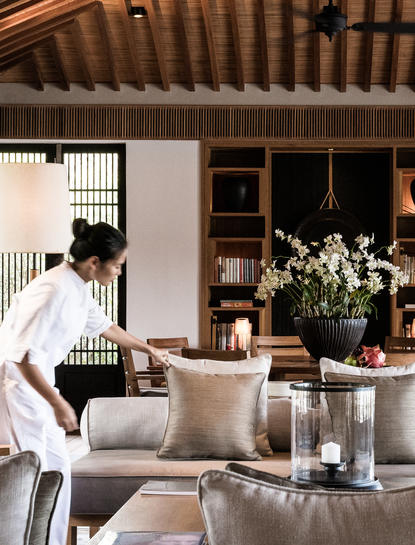 安缦诺怡度假村的休闲区，宽敞的空间内有米色座椅、木质天花板和白色花卉装饰。