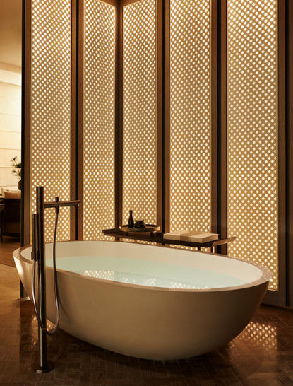 Vasca da bagno freestanding con parete a pannelli nella suite dell'Aman New York.