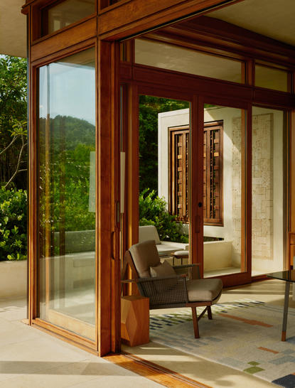 Salon avec portes en bois ouvrant sur la verdure, Amanera.