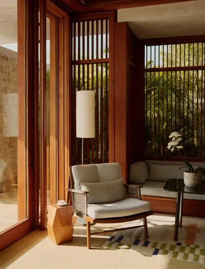 Sala de estar de la casa de dos dormitorios en el resort Amanera, con puertas de madera y mobiliario contemporáneo.