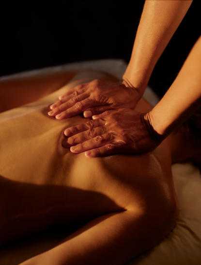 Therapist's hands applying therapeutic treatment to guest's back at Amanera spa.