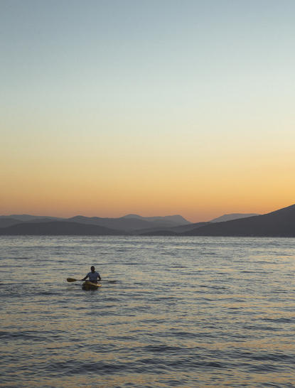 Person canoeing on calm waters at sunset, Amanruya, Turkey.