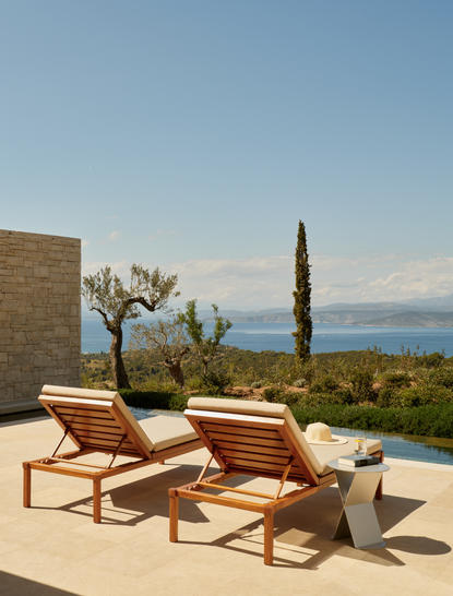 安缦卓熠度假村的豪华池畔别墅露台，配有木制躺椅和爱琴海景观。