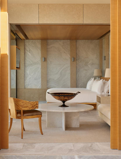 安缦卓熠度假村的亭阁式住宿，木框架天花板、石灰岩墙壁和简洁床铺。