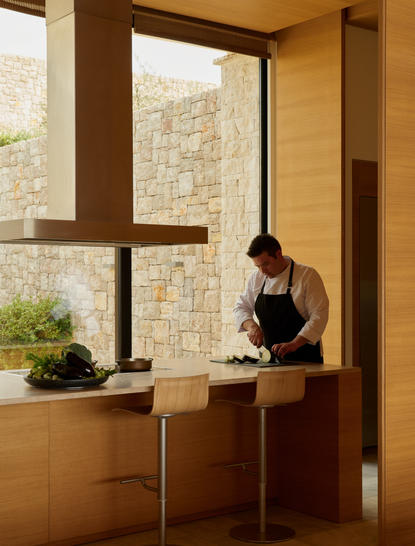 Femme assise à la fenêtre d'une villa à Amanzoe, resort en Grèce.