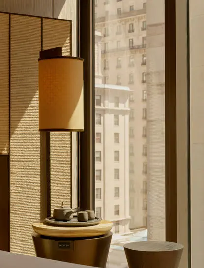 Suite Premier de l'hôtel Aman New York avec vue sur Manhattan depuis la fenêtre.