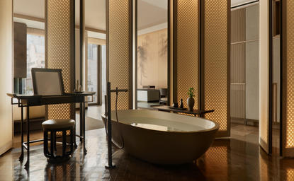 Salle de bains de la suite Deluxe à l'Aman New York avec baignoire ovale et bureau.