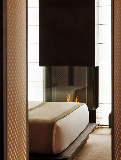 Suite déluxe à Aman New York, lit avec baldaquin noir et draps crème, vue depuis l'entrée.