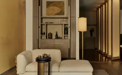 Lounge de la suite Grand à Aman New York, avec fauteuils crème et détails architecturaux épurés.