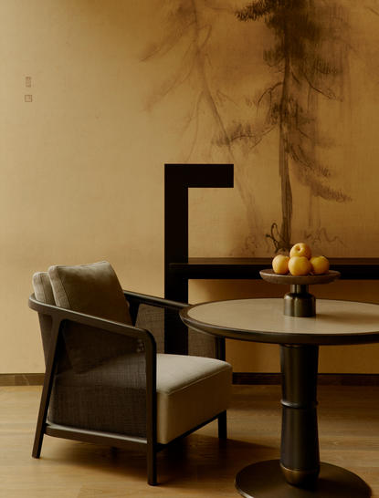 Détail du mur d'une suite à Aman New York, avec chaise noire et table basse minimaliste.