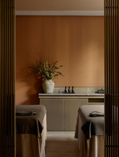 Sala de tratamento spa do Aman New York, com bancada clara, espelho e plantas.