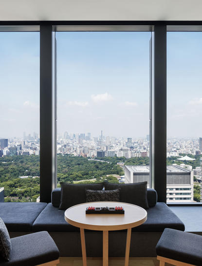 安缦东京酒店豪华套房卧室窗景，俯瞰东京城市天际线。