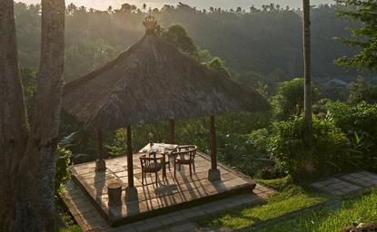 طاولة الطعام الخاصة عند الغروب وسط الحديقة الاستوائية في منتجع أمانداري بإندونيسيا.