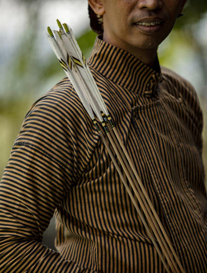 Wellness guide at Amanjiwo holding traditional palm leaf offerings during jemparingan ceremony, Central Java.