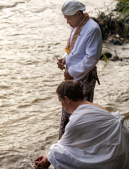 Wellness guide conducting a ruwatan cleansing ritual at Amanjiwo resort in Central Java, Indonesia.