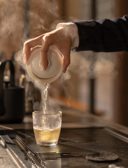 养云安缦茶馆中，调酒师将琥珀色液体倒入玻璃杯。