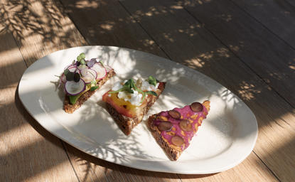 安缦纽约酒店早餐，白瓷盘上盛放着煎蛋、新鲜蔬菜和火腿，阳光透过窗户洒下。