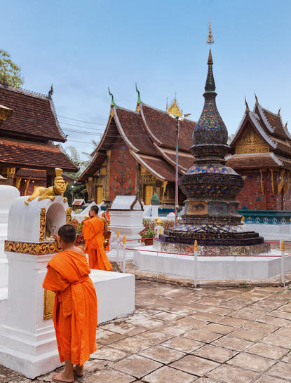 Buddhist monk in saffron robes at Amantaka's temple during a guided tour, Laos.