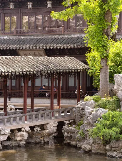 养云安缦度假村的传统中式建筑，白墙黑瓦屋顶，庭院内有清池和绿植。