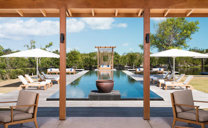 アマンヤラのヴィラ外観、木製柱のテラスから見る無限プールと庭園景観