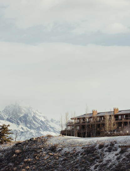 Amangani's stone architecture set against snow-capped Teton peaks in winter.