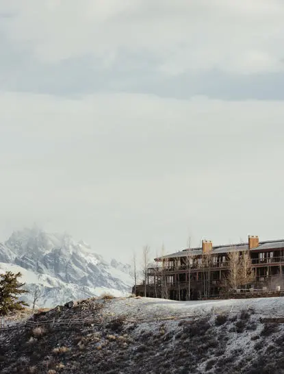 Amangani's stone architecture set against snow-capped Teton peaks in winter.