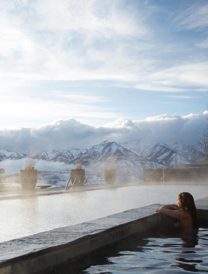 Outdoor spa pool at Amangani overlooking snow-capped mountains and misty valley below.
