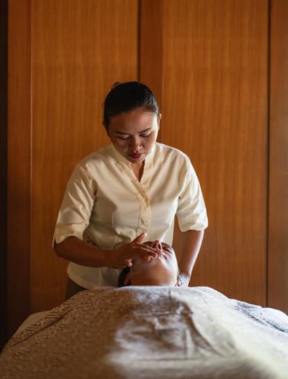 Thérapeute effectuant un soin du bien-être à Amankila, resort à Bali.