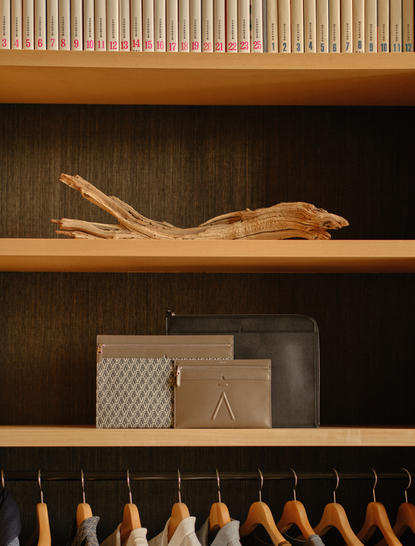 Aman Tokyo Essentials Boutique shelving displaying folded garments and wooden accessories.